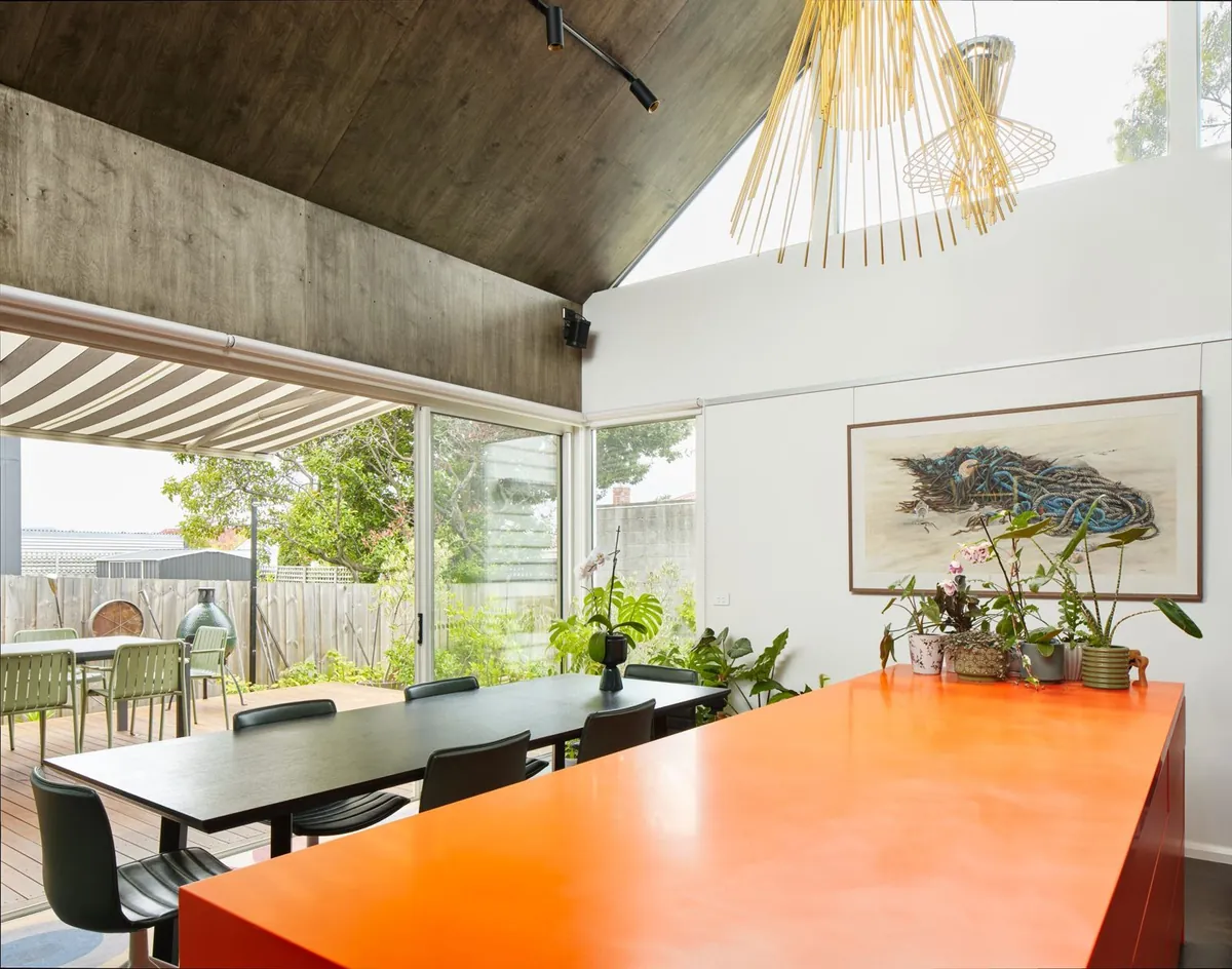 Renovated open-plan dining room with timber ceiling and pendant lights