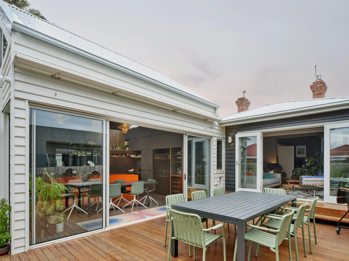 Andrew Francis House extension at dusk with new deck and full-height glazing