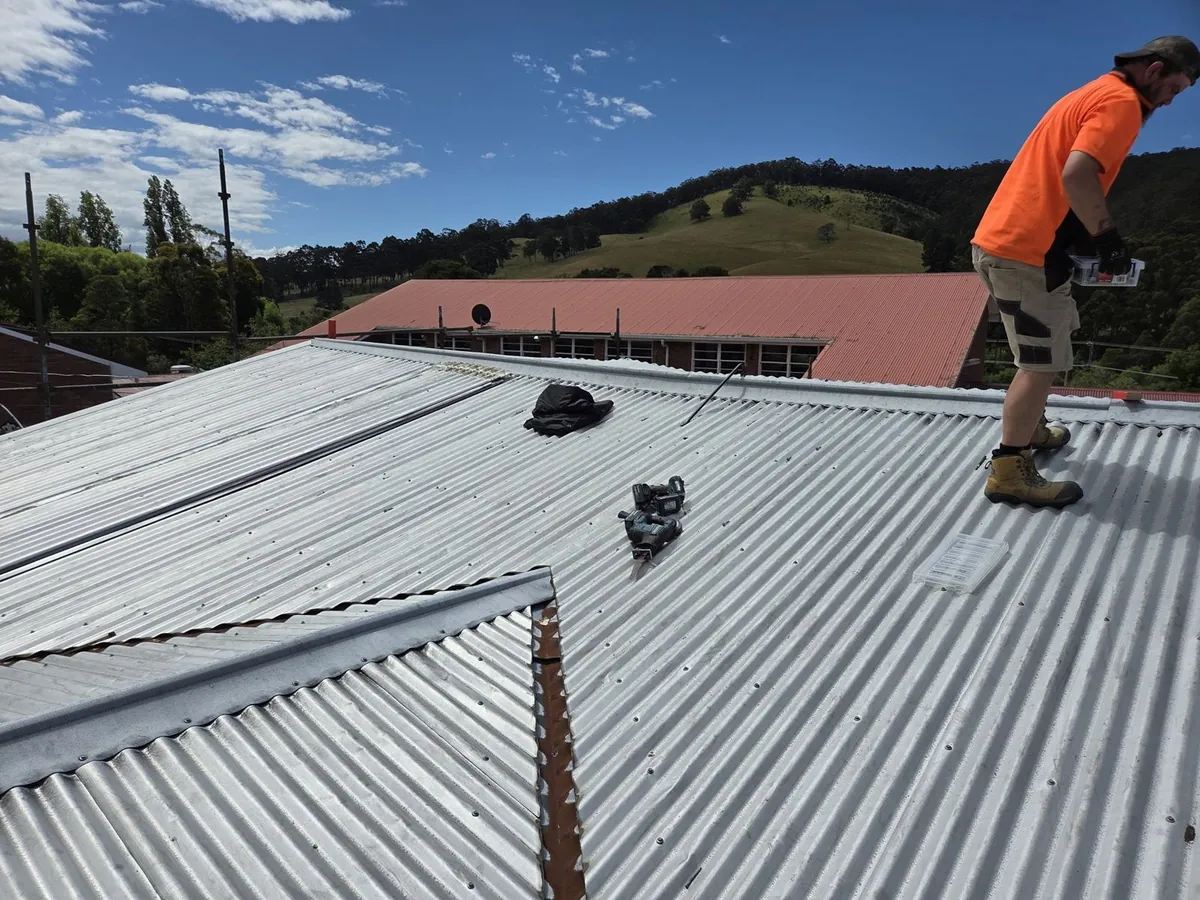 Allen Built tradesperson working on a corrugated iron roof in Dover