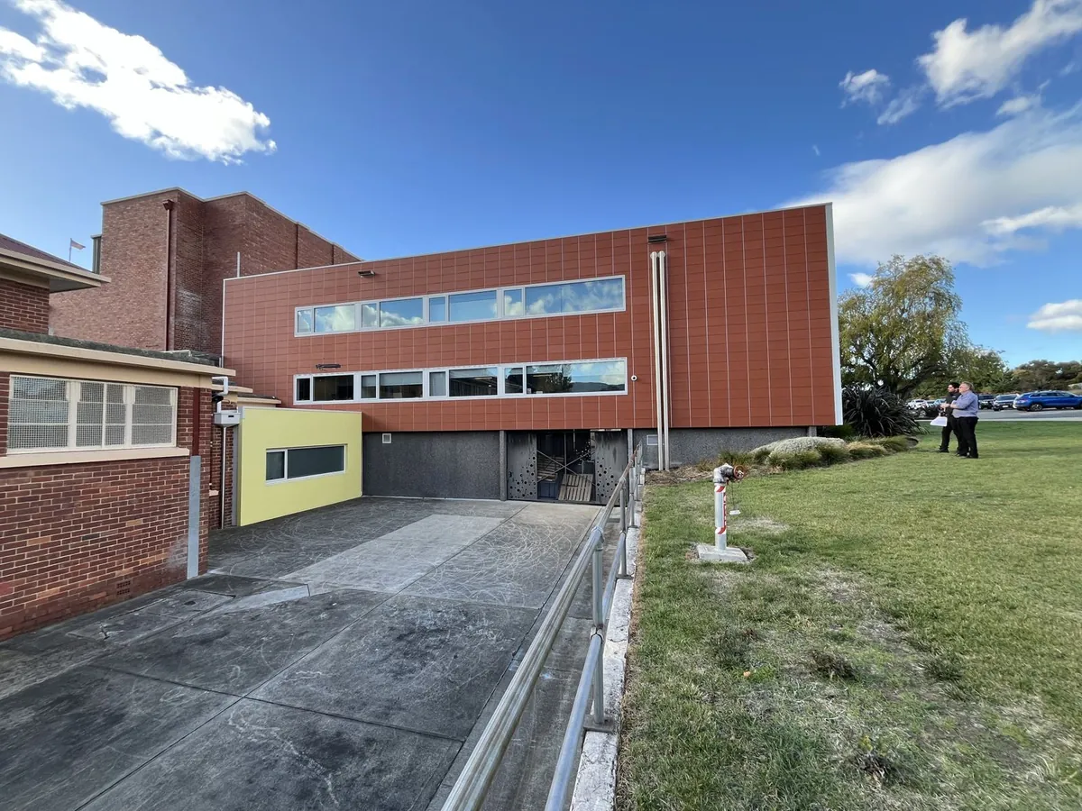 Red brick school building with a new covered walkway built by Allen Built