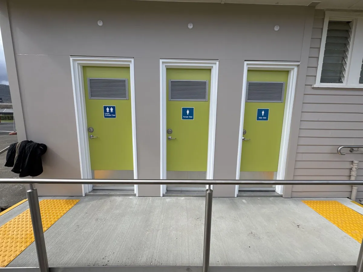 New accessible amenities block with lime green doors and tactile paving at New Norfolk High School